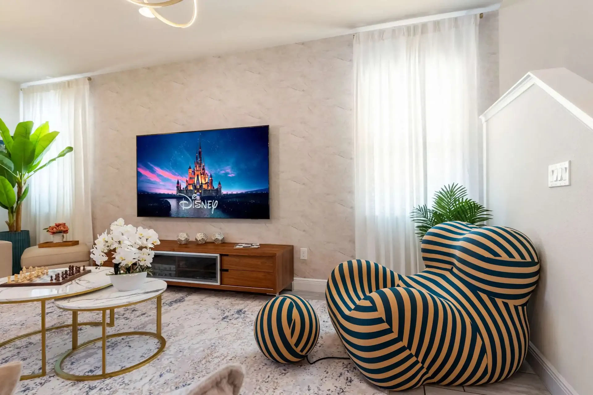 Lounge with statement striped chair and Disney TV