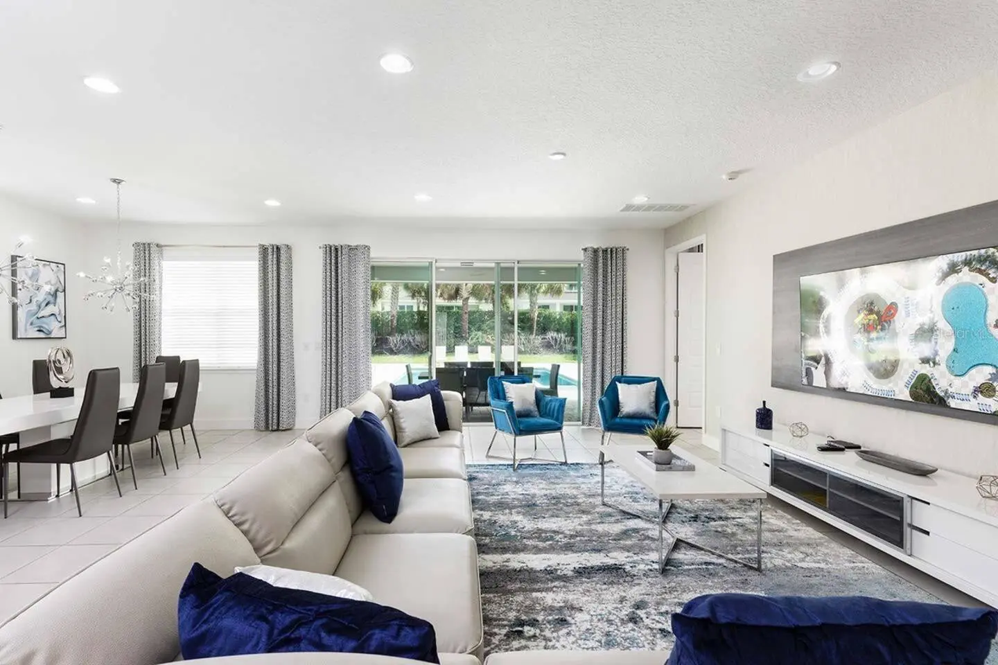 Open living room with sectional sofa, blue armchairs and dining area