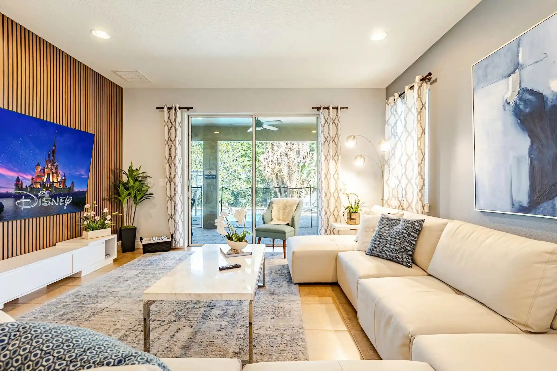 Bright living area with sectional sofa and sliding doors to the pool