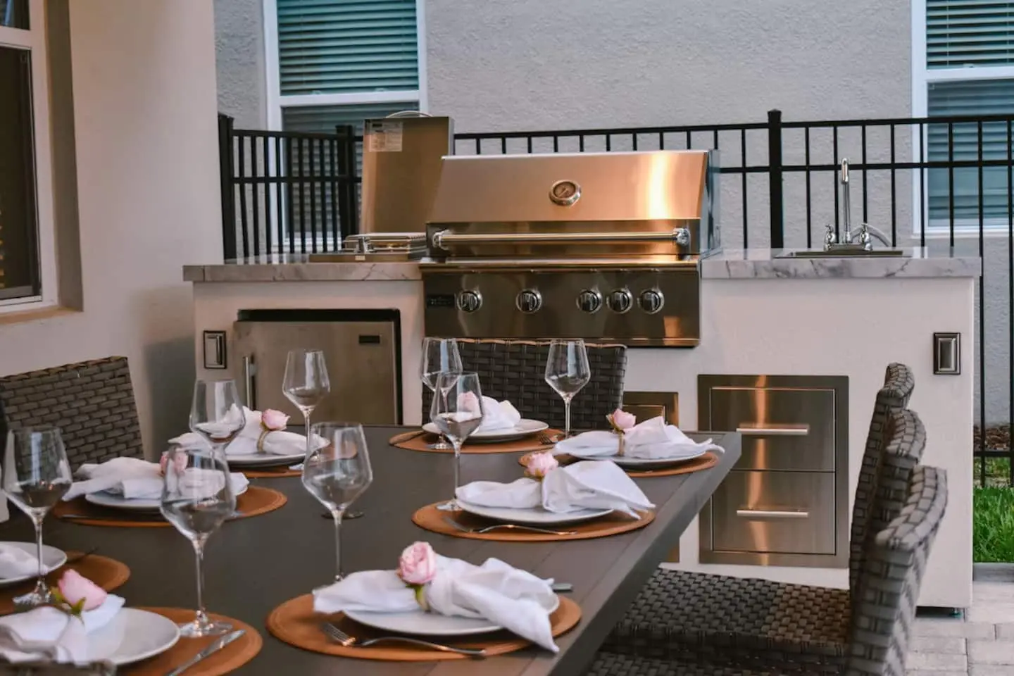 Outdoor dining table set beside the built-in barbecue kitchen